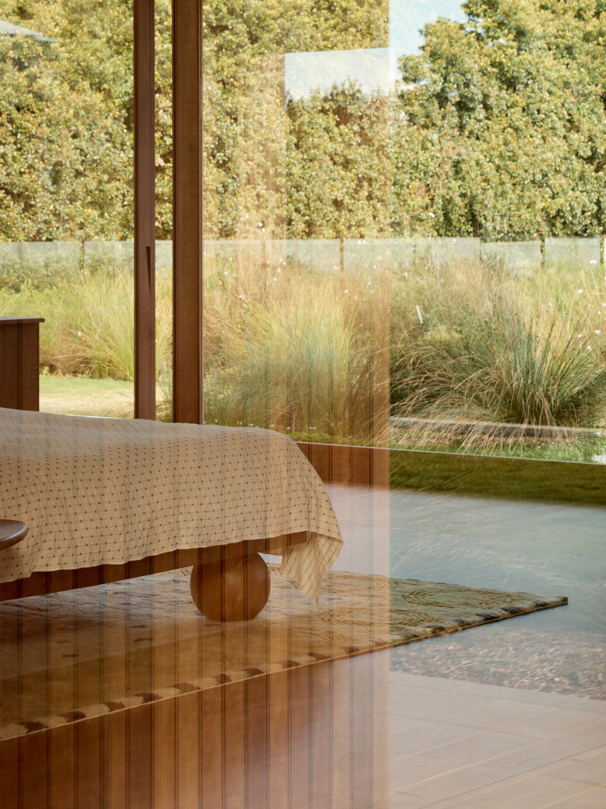 A bed beside a window looking onto a garden